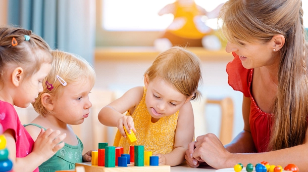 Kleine Kinder spielen mit Betreuerin